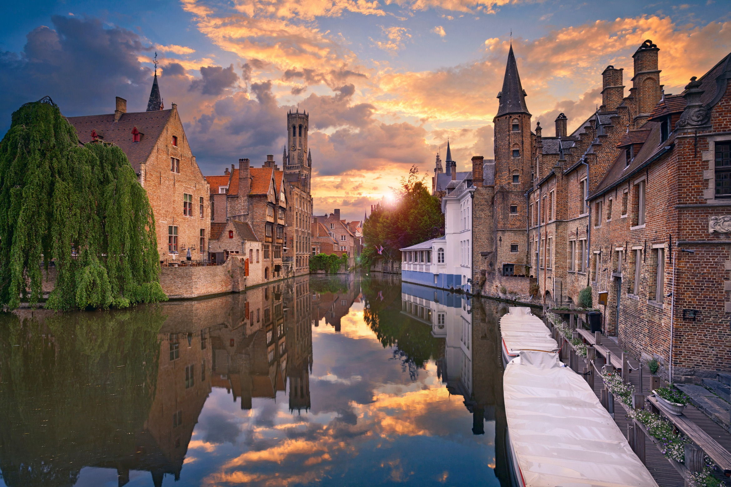 Kanal mit Brücken und Booten am Rand des Stadtkerns von Brügge im Sonnenuntergang; Wirtschaftsdetektei Brügge